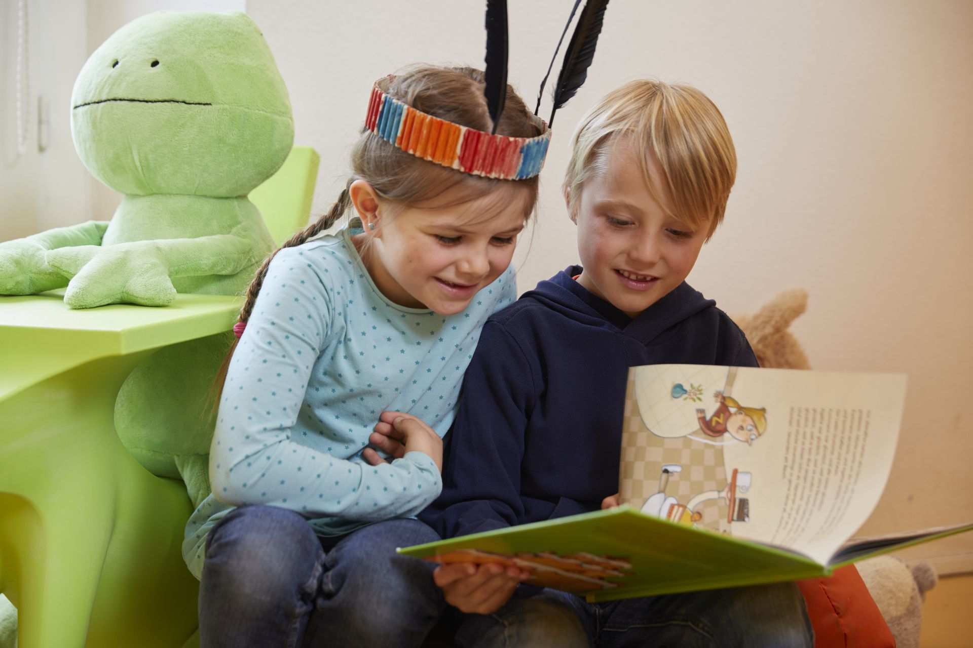 Zwei Kinder lesen gemeinsam in einem Buch
