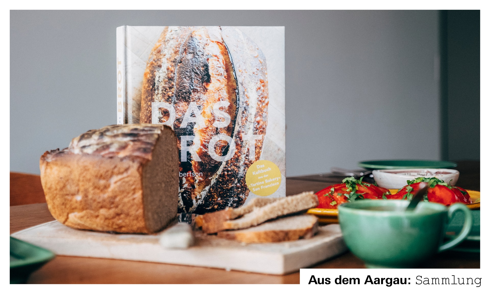 Foto mit Kochbuch, Brot und Beilagen