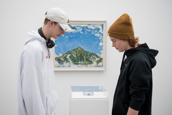 zwei junge Männer stehen vor einem Bild eines Berges